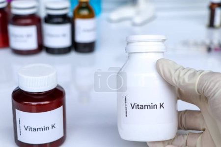 Téléchargez les photos : Pilules de vitamine K dans une bouteille, complément alimentaire pour la santé ou utilisé pour traiter la maladie - en image libre de droit