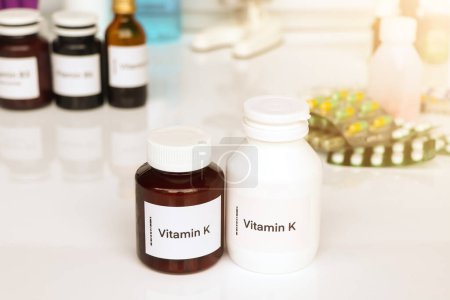 Téléchargez les photos : Pilules de vitamine K dans une bouteille, complément alimentaire pour la santé ou utilisé pour traiter la maladie - en image libre de droit