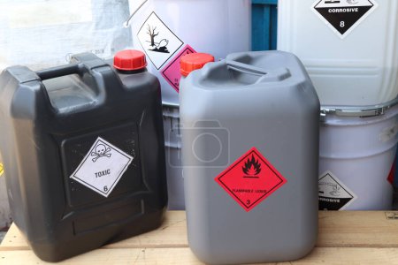 Símbolos químicos corrosivos en un tanque químico negro, productos peligrosos en la industria