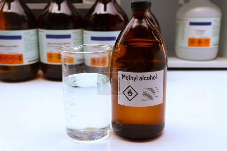 Téléchargez les photos : Alcool méthylique dans le verre, produits chimiques dangereux et symboles sur les récipients dans l'industrie ou le laboratoire - en image libre de droit