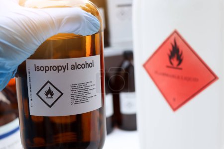 Téléchargez les photos : Alcool isopropylique dans le verre, Produits chimiques dangereux et symboles sur les récipients dans l'industrie ou le laboratoire - en image libre de droit
