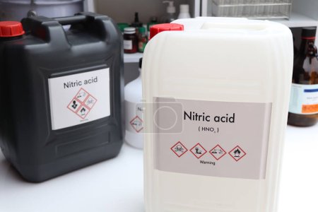Foto de Ácido nítrico, productos químicos peligrosos y símbolos en recipientes, productos químicos en la industria o el laboratorio - Imagen libre de derechos