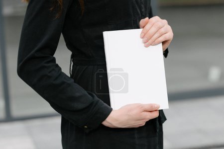 Foto de Portada de libro blanco en manos de mujer. Portada de libro para maqueta - Imagen libre de derechos