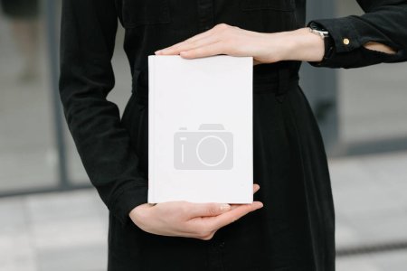 Foto de Portada de libro blanco en manos de mujer. Portada de libro para maqueta - Imagen libre de derechos