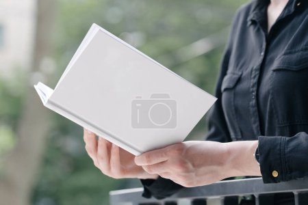 Téléchargez les photos : Couverture de livre blanc entre les mains de la femme. Couverture de livre pour maquette - en image libre de droit