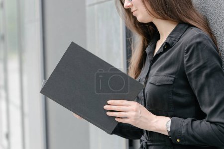 Foto de Cubierta de libro negro en manos de mujer. Portada de libro para maqueta - Imagen libre de derechos