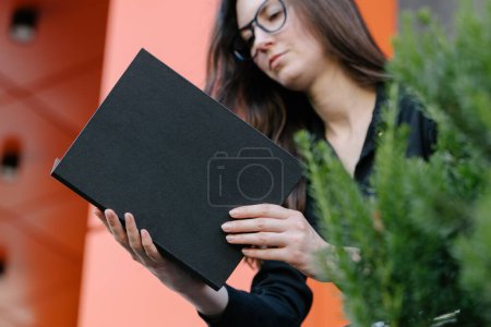 Photo for Black book cover in woman's hands. Book cover for mock up - Royalty Free Image