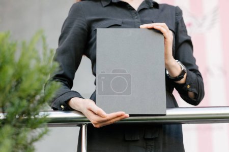 Foto de Cubierta de libro negro en manos de mujer. Portada de libro para maqueta - Imagen libre de derechos