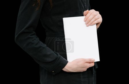 White book cover in woman's hands  isolated on black color
