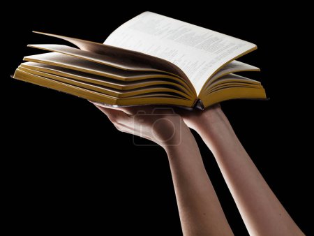 Téléchargez les photos : Bible dans les mains de la femme sur isolé sur la couleur noire - en image libre de droit