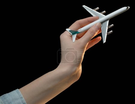 Téléchargez les photos : Femme main tenant un avion jouet isolé sur la couleur noire - en image libre de droit