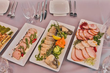 Various light snacks of meat, salad, fish are on table served for gala dinner, party, picnic. Enjoying taste. Menu for holidays, weddings, parties. Specialties and recipes. Cold snacks. 