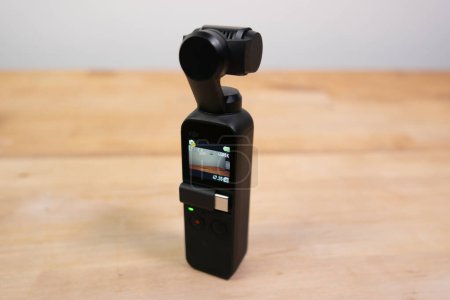 Téléchargez les photos : Caméra à cardan électronique portable DJI Osmo Pocket sur une table en bois avec écran LCD. - en image libre de droit