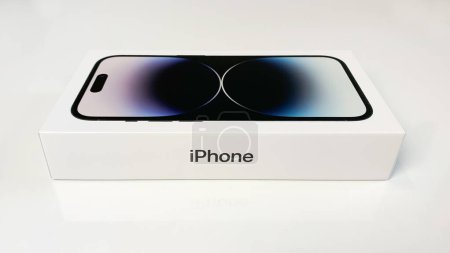 Téléchargez les photos : Apple iPhone 14 Pro en boîte sur table blanche, vue de côté. - en image libre de droit