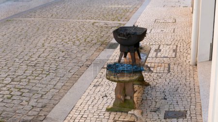Téléchargez les photos : Vieille grille de charbon de fer pour griller les sardines. Gauche dans la rue à Povoa de Varzim après le festival Sao Pedro. - en image libre de droit