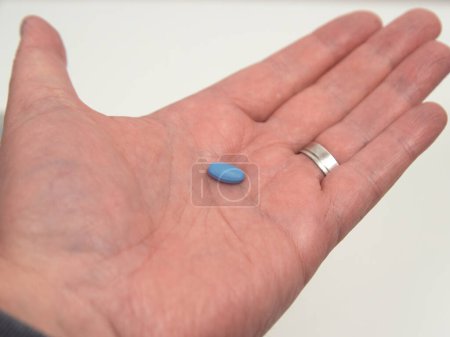 Blaue Pille zur Behandlung von Erektionsstörungen oder Impotenz. Eine einzige Pille in der Hand.