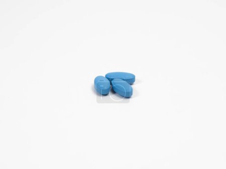 Blaue Pillen zur Behandlung der erektilen Dysfunktion auf einem weißen Tisch