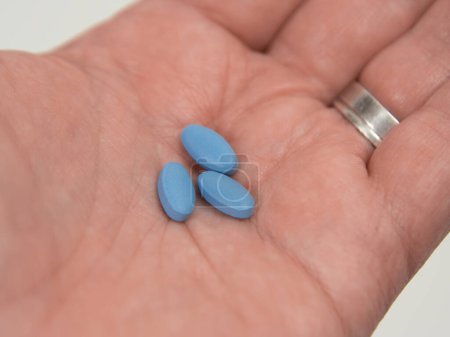Blaue Scheine für erektile Dysfunktion in der Handfläche gehalten.