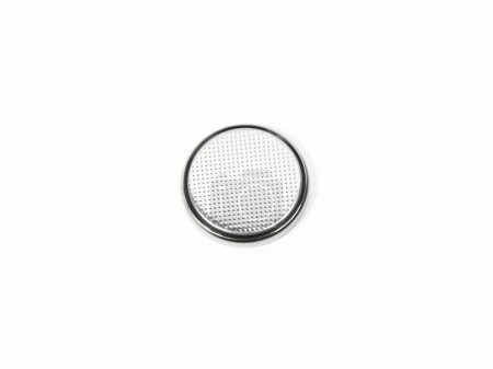 One single CR2032 button cell battery on a white background. Close up.