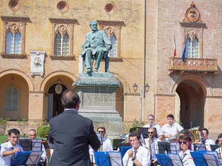 Foto de Orquesta actuando al aire libre justo en frente de Rocca Pallavicino y la estatua de Giuseppe Verdi, compositor italiano, Parma, Italia. - Imagen libre de derechos
