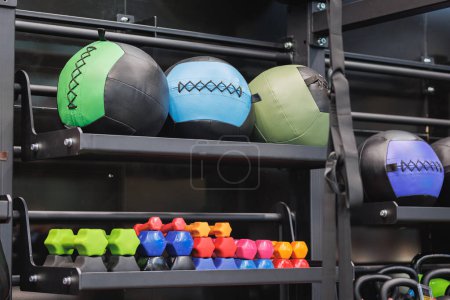 Bolas coloridas de la medicina de la aptitud y otro equipo dentro del gimnasio.