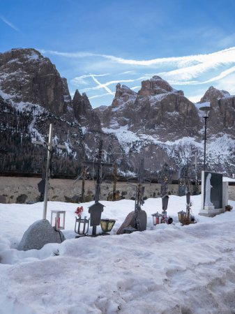 Friedhof von Colfosco bei der Kirche in den italienischen Alpen im Winter, Italien.