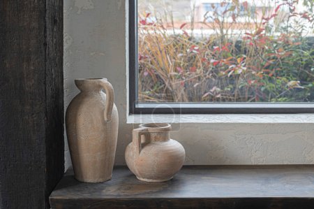 Foto de Dos jarrones de cerámica vintage frente a la ventana - Imagen libre de derechos