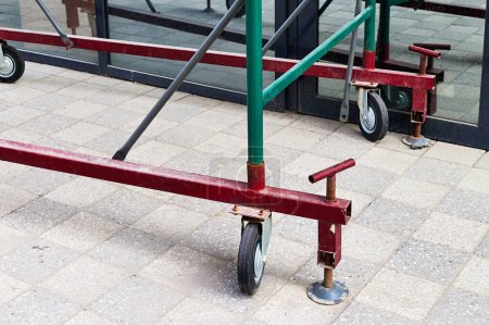 support of scaffolding on wheels and screw jacks installed near the shop window