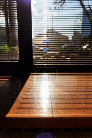 Schatten von den Jalousien auf der Fensterbank