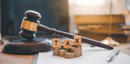 Photo for Tax law concept. Wooden blocks word " TAX" on coin stack  .with gavel and money on the table. - Royalty Free Image