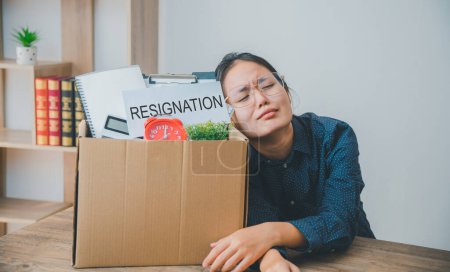 Téléchargez les photos : Employée de l'entreprise stressée et fatiguée après avoir quitté son emploi pour chercher un nouvel emploi, licenciée ou licenciée par l'employeur - en image libre de droit