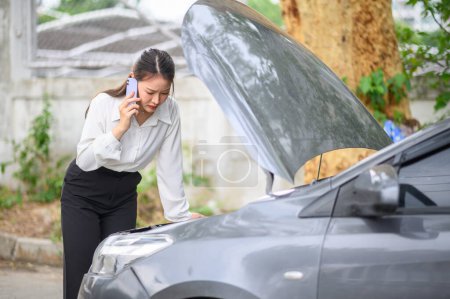 Foto de Mujer motorista está llamando a un oficial de seguros o de servicio de recuperación para asistencia relacionada con un accidente de coche. - Imagen libre de derechos