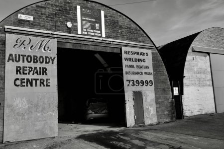 Photo for Barry, Vale of Glamorgan, Wales 02 Feb 2024: Arched vintage industrial units on dockland close to new residential construction sites on the waterfront of Barry - Royalty Free Image