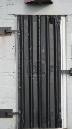 Sichere graue Tür auf einem Schloss in einem Industriegebiet auf dem Hafengelände von Barry.