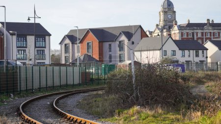 Photo for Barry dock regeneration: the old rail tracks run behind the latest phase of new houses at East Quay. The site is on the perimeter of the industrial sites next to number 2 dock and the port of Barry. - Royalty Free Image