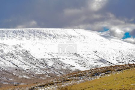 Photo for Welsh mountain winter landscape. Snow on the top of the mountains above Storey Arms in the Brecon Beacons.  Icy conditions but the sun is shining and has melted the snow of the foothills. - Royalty Free Image