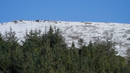 Die walisische Berglandschaft. Schnee auf den Gipfeln der Berge über Storey Arms in den Brecon Beacons. Eisige Bedingungen, aber die Sonne scheint und hat den Schnee der Ausläufer geschmolzen.