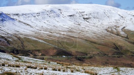 Paisaje de invierno de montaña galesa. Nieve en la cima de las montañas por encima de Storey Arms en las balizas Brecon. Las condiciones heladas, pero el sol está brillando y ha derretido la nieve de las estribaciones.