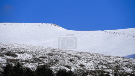 Paisaje de invierno de montaña galesa. Nieve en la cima de las montañas por encima de Storey Arms en las balizas Brecon. Las condiciones heladas, pero el sol está brillando y ha derretido la nieve de las estribaciones.