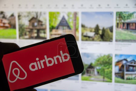 Foto de Rheinbach, Alemania 8 de diciembre de 2022, El logotipo de la marca "Airbnb" en una pantalla de teléfono inteligente frente al sitio web (enfoque en el logotipo de la marca) - Imagen libre de derechos
