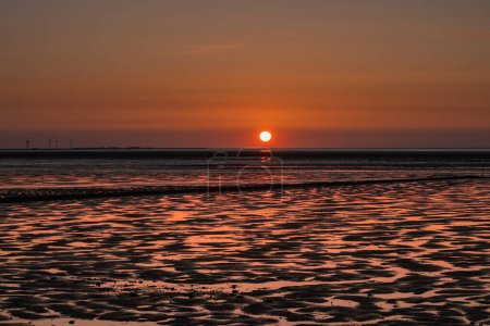 Sonnenuntergang bei Ebbe auf der Halbinsel Nordstrand mit Blick auf die Halligen