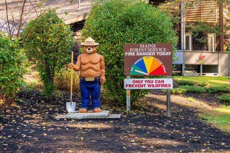 Téléchargez les photos : Kittery, ME - 19 octobre 2022 : Smokey the Bear se tient à côté d'un feu de forêt du Maine Service Danger Aujourd'hui signe avec "Only You Can Prevent Forest Fires" à la route 95 nord, arrêt de repos Turnpike du Maine - en image libre de droit