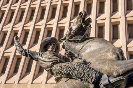 Photo for Phoenix, AZ - Nov. 10, 2022: Detail of bronze cowboy sculptue downtown in front of the Calvin C. Goode Municipal Building called "Lariat Cowboy" by Constance Whitney Warren. - Royalty Free Image