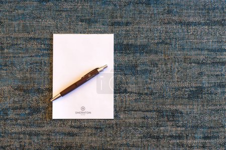 Photo for Chandler, AZ - Nov. 20, 2022: Sheraton pen and pad on a textured background. Sheraton Hotels and Resorts is a hotel chain owned by Marriott International. - Royalty Free Image