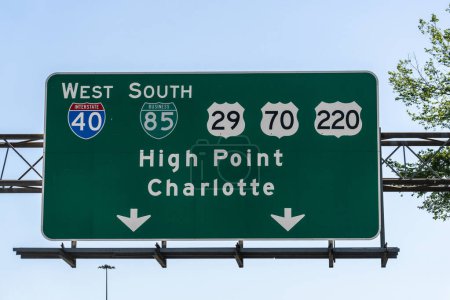 Foto de Greensboro, NC - April 24, 2022: Sign on S O Henry Blvd, Routes 29, 70, and 220, for Interstate 40 West and Business 85 South, High Point and Charlotte. - Imagen libre de derechos