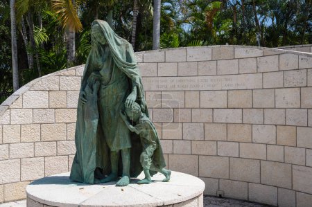 Photo for Miami, Florida - April 2, 2024: The First Sculpture at the Miami Beach Holocaust Memorial by Ken Treister depicts a mother and children with a quotation by Anne Frank on the wall behind. - Royalty Free Image