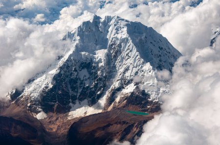 Luftaufnahme des großen schneebedeckten Berges mit türkisfarbenem See, Anden-Gebirge