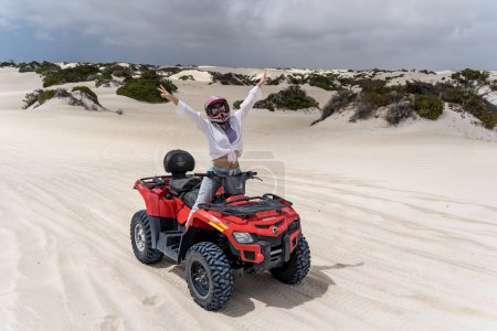 Turista femenina en quad bike. Dunas de arena Lancelin, Australia Occidental. 