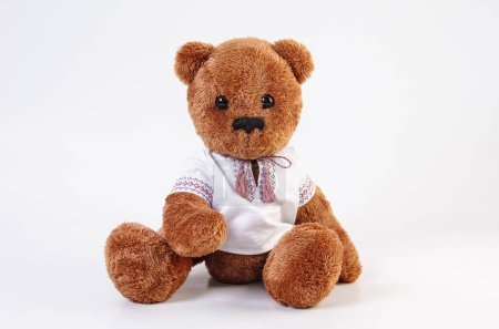 Photo for Soft toy. Teddy bear in an embroidered shirt on a white background. - Royalty Free Image