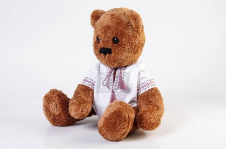 Photo for Soft toy. Teddy bear in an embroidered shirt on a white background. - Royalty Free Image